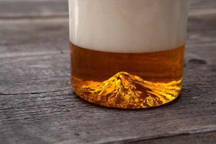 Amigos lançam copo de cerveja feita a mão com detalhes de montanha
